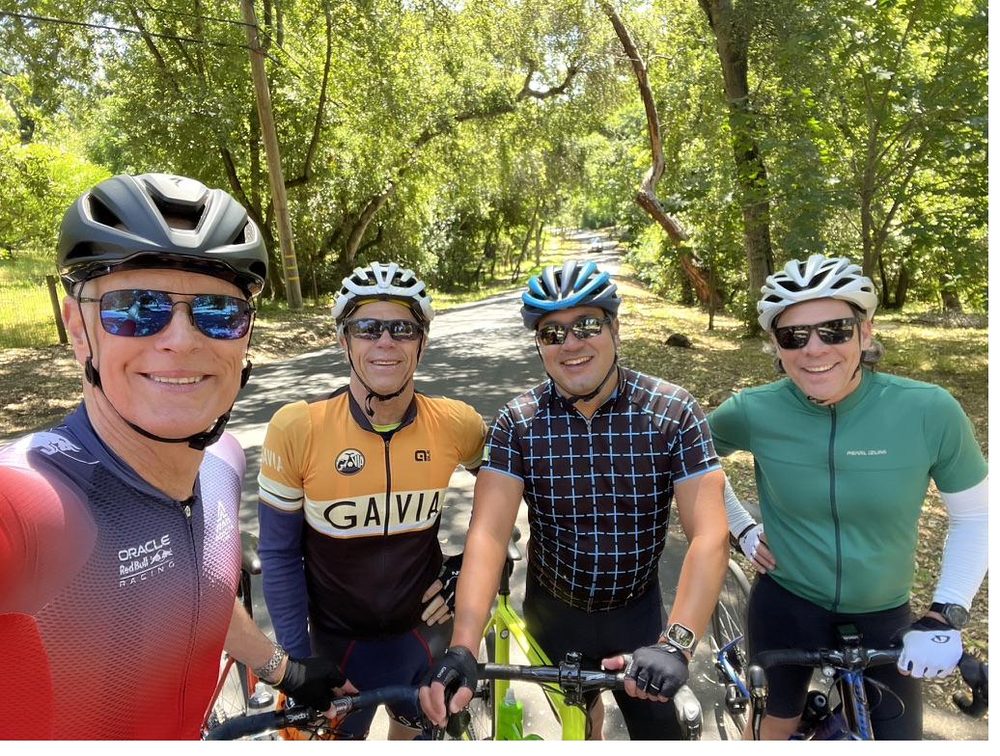 Crick Waters cycling on a tree-lined Bay Area road